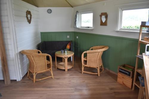 Zimmer mit 2 Stühlen, einem Tisch und einem Sofa in der Unterkunft 't Peelhuisje in Kronenberg