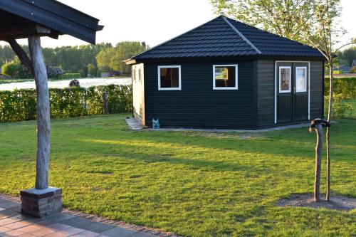 een klein zwart huis in een tuin bij 't Peelhuisje in Kronenberg