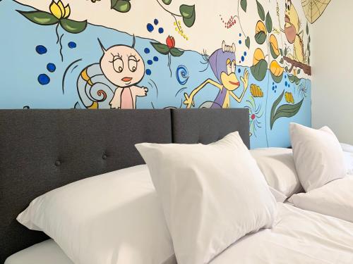 a bedroom with a bed with a mural on the wall at Mese Panzió Zalakaros in Zalakaros