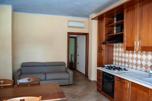 Küche und Wohnzimmer mit Sofa in der Unterkunft Appartamenti Medusa in Alba Adriatica