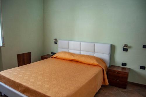 ein Schlafzimmer mit einem großen Bett mit einer orangefarbenen Decke in der Unterkunft Appartamenti Medusa in Alba Adriatica
