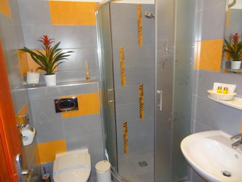 a bathroom with a shower and a toilet and a sink at Residence Parliament in Budapest