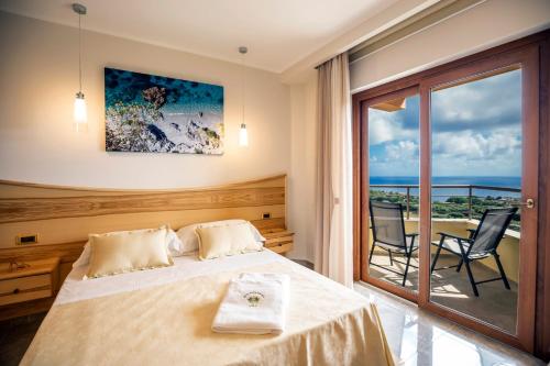 ein Hotelzimmer mit einem Bett und einem Balkon in der Unterkunft Hotel Santa Chiara in Capo Vaticano