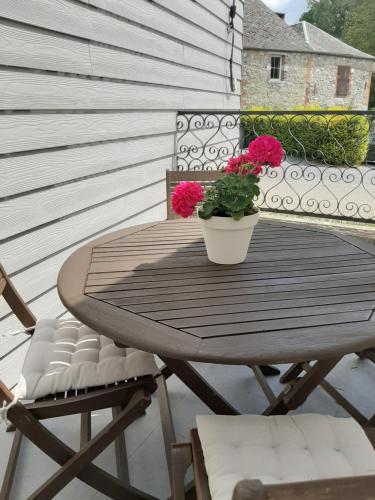 a wooden table with a potted plant on a balcony at Maison de campagne en pierre bleue-WIFI et parking in Bousignies-sur-Roc