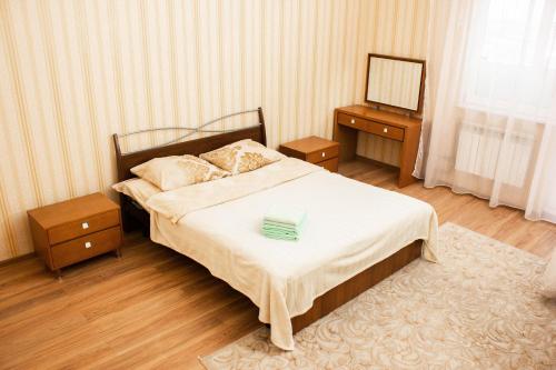 a bedroom with a bed with a mirror and a table at Мода в доме 05 in Uralsk