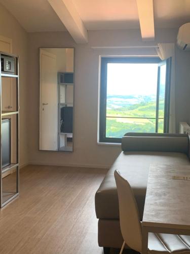 a living room with a table and a large window at Hotel Bel Soggiorno in San Gimignano