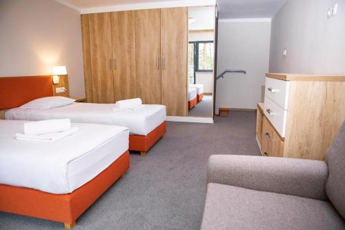 una camera d'albergo con due letti e un divano di Leśna Oaza a Śliwice