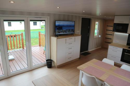 a kitchen with a deck with a television and a table at Amis apartmán 1 in Liptovský Mikuláš