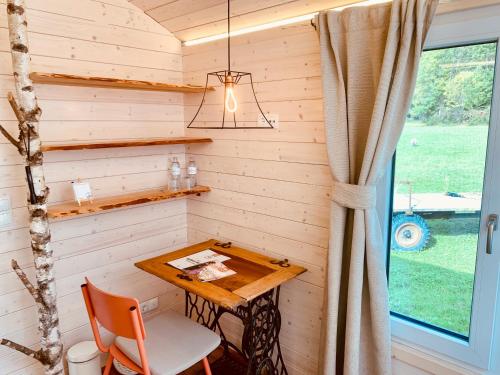 a table in a tiny house with a window at Das Franzl - Bett & Brot in St. Wolfgang