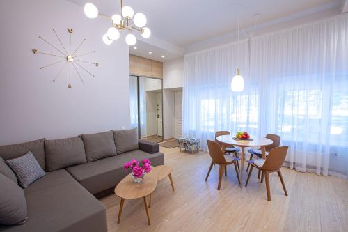 ein Wohnzimmer mit einem Sofa und einem Tisch mit Stühlen in der Unterkunft Apartment near Baltic Sea in Jūrmala