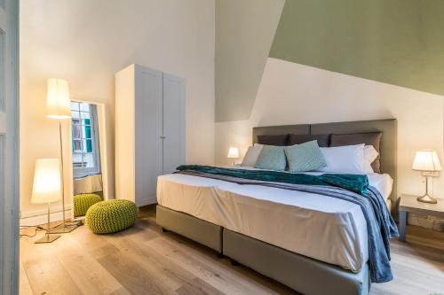 una camera con un grande letto e due lampade di Family Apartments San Lorenzo a Genova