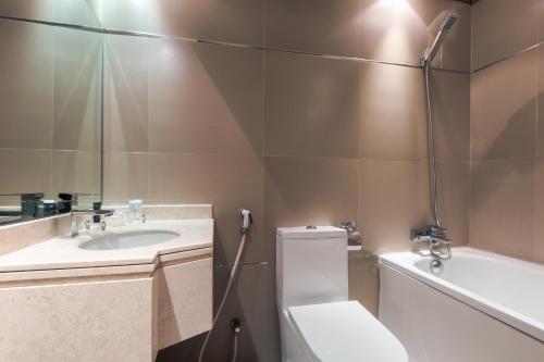 a bathroom with a toilet and a sink and a tub at Al Muhaidb Residence Al Takhassusi in Riyadh