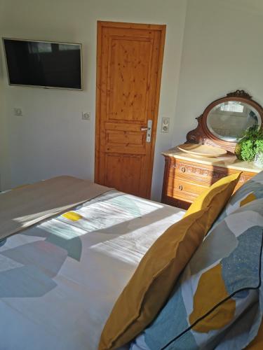 ein Schlafzimmer mit einem Bett, einer Kommode und einem TV in der Unterkunft Studio de charme en Provence in Le Luc