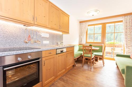 une cuisine avec des placards en bois et une salle à manger dans l'établissement Appartementhaus Schützenhof Schied, à Grossarl