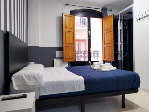 - une chambre avec un lit et une douche dans l'établissement Flats Friends Plaza de la Reina, à Valence