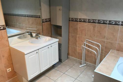 La salle de bains est pourvue d'un lavabo blanc et d'un comptoir. dans l'établissement Maison spacieuse, à Gruissan