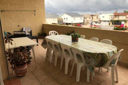 une table et des chaises sur un balcon avec vue dans l'établissement Maison spacieuse, à Gruissan