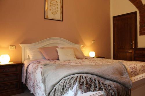 een slaapkamer met een groot bed met 2 lampen bij Veramaro,accogliente appartamento in campagna in Arezzo