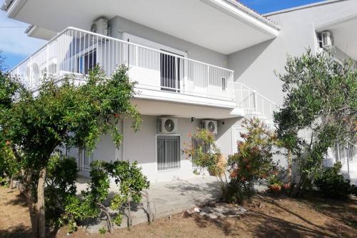 a white house with trees in front of it at Family Maisonette with pool #2 in Nea Fokea