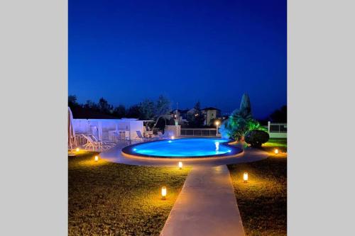a swimming pool with lights in a yard at night at Family Maisonette with pool #2 in Nea Fokea