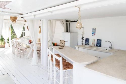 a kitchen with white counters and a table and chairs at Family Maisonette with pool #2 in Nea Fokea