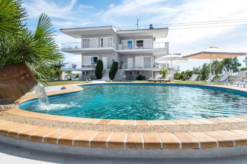 a swimming pool in front of a house at Family Maisonette with pool #2 in Nea Fokea