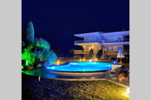 a swimming pool in front of a house at night at Family Maisonette with pool #2 in Nea Fokea