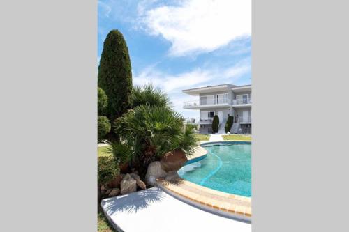 a villa with a swimming pool in front of a building at Family Maisonette with pool #2 in Nea Fokea