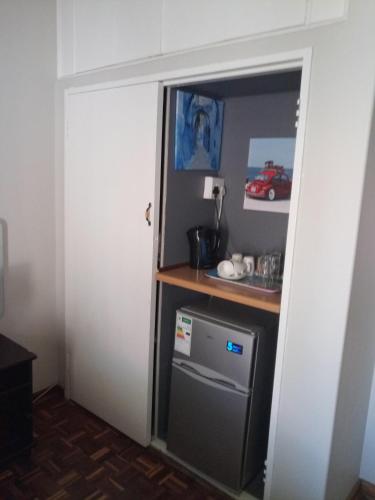 a door leading into a kitchen with a small refrigerator at Caledon Overnight Rooms in Kimberley