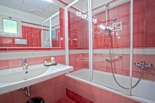 a red bathroom with a shower and a sink at Hotel Santa Caterina in Palinuro
