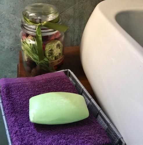 a bar of soap sitting on a purple towel next to a sink at Soggiorno in Relax in Correggioverde