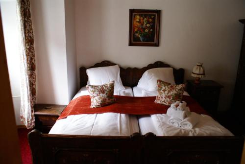 a bed with white sheets and a teddy bear on it at Historisches Hotel Piz Ela Bergün in Bergün