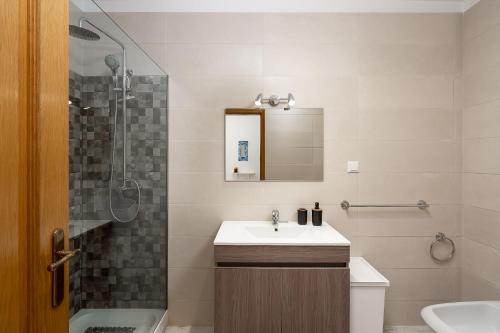 uma casa de banho com um lavatório e um chuveiro em Heritage Aqua em Portimão