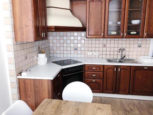 a small kitchen with wooden cabinets and a sink at Apartment Mario in Piran