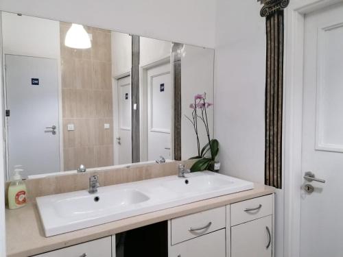 a bathroom with a sink and a large mirror at Chiado Open World Hostel in Lisbon