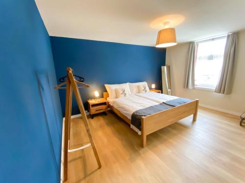 una camera da letto con una parete blu e un letto di Madulain Lodge @ Werkhof a Madulain