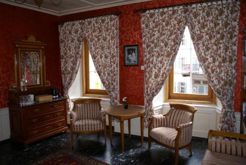 a room with two chairs and a table and a window at Historisches Hotel Piz Ela Bergün in Bergün