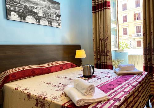 a bedroom with a bed with towels and a window at Sweet Dream Roma Termini in Rome