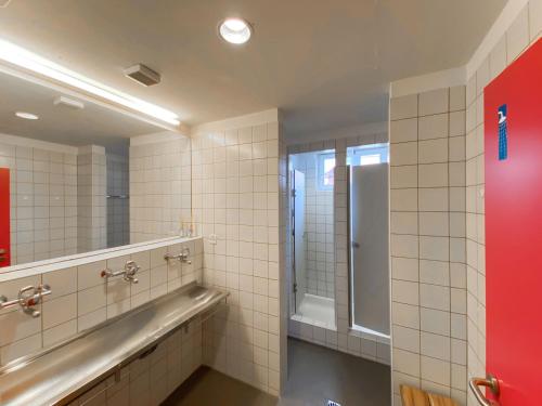 a bathroom with a large mirror and a shower at Madulain Lodge @ Werkhof in Madulain