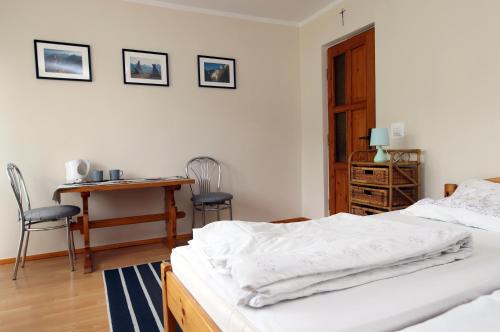 a bedroom with a bed and a desk and chairs at Pokoje u flisaka in Krościenko