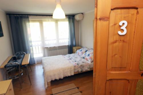 a small bedroom with a bed and a window at Pokoje u flisaka in Krościenko