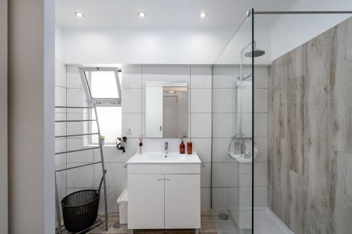 La salle de bains blanche est pourvue d'un lavabo et d'une douche. dans l'établissement Heritage Caeli, à Portimão