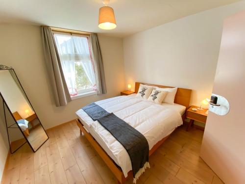 a bedroom with a bed and a large window at Madulain Lodge @ Werkhof in Madulain