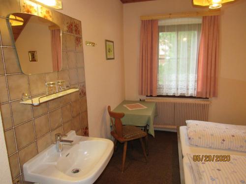 a bathroom with a sink and a mirror and a table at Villa Löcker in Mariapfarr