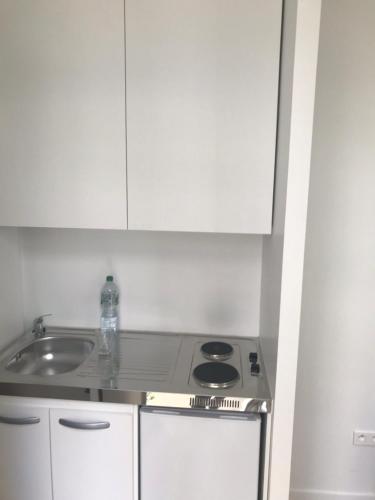 a white kitchen with a stove and a sink at Studio - Central Paris in Paris