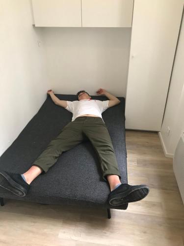 a man laying on a bed in a room at Studio - Central Paris in Paris