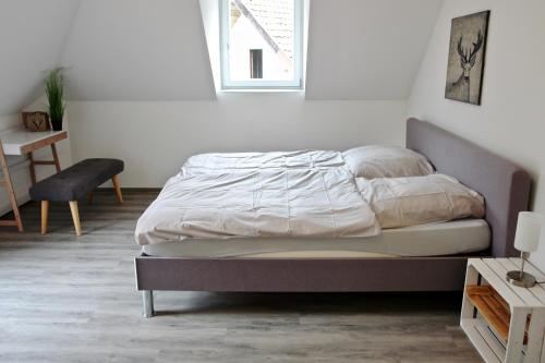 1 dormitorio con 1 cama en una habitación blanca en Dom-i-Ziel Apartments en St. Blasien