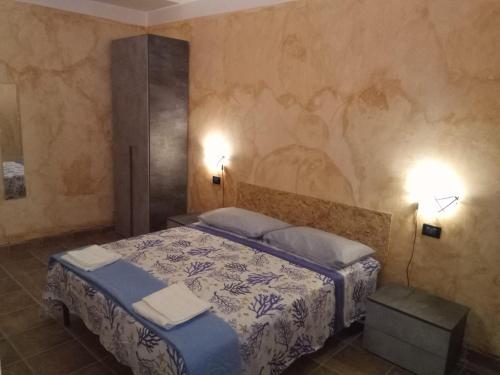 a bedroom with a bed and two lights on the wall at Al vico art in Crosia