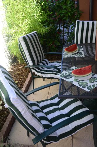 two chairs and a table with watermelon plates on them at AnMa Cottages The Secret Garden in Pianello Del Lario