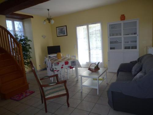 a living room with a table and a couch at Gîte Le Logis de Faugerit in Frontenay-Rohan-Rohan